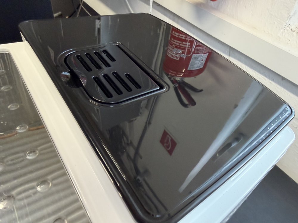 Capac și panou superior curățate ale unui aparat de cafea recondiționat DeLonghi Capac și panou superior curățate ale unui aparat de cafea recondiționat DeLonghi