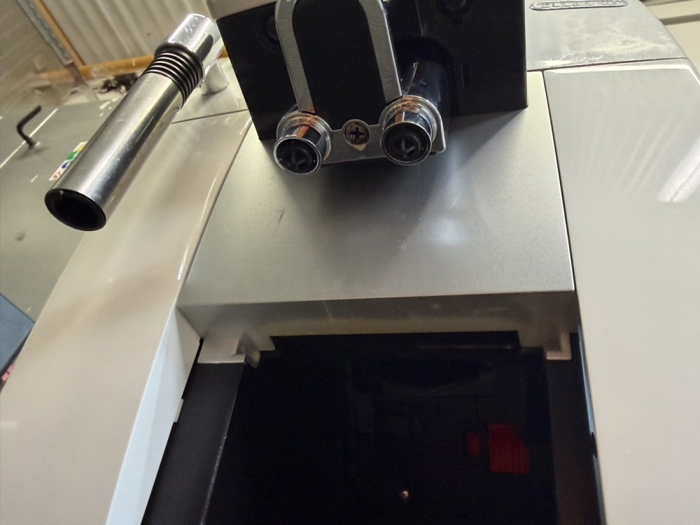 Pâlnia pentru boabe și bagheta de abur ale unui aparat de cafea recondiționat DeLonghi Pâlnia pentru boabe și bagheta de abur ale unui aparat de cafea recondiționat DeLonghi
